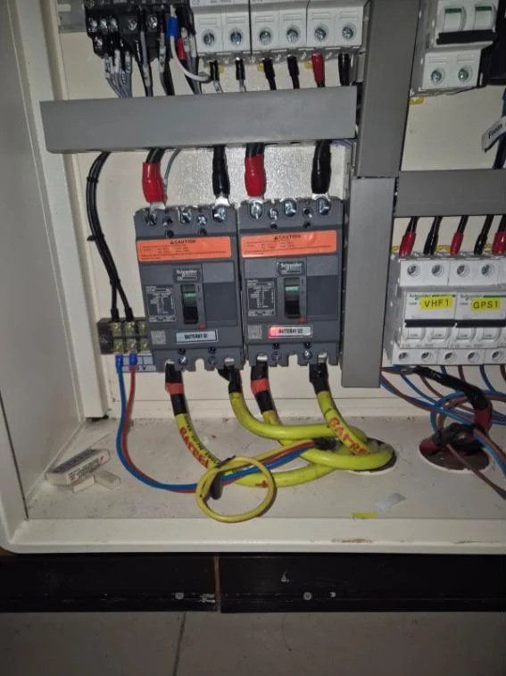 Commercial vessel switchboard with Schneider battery breakers and labelled VHF and GPS circuits