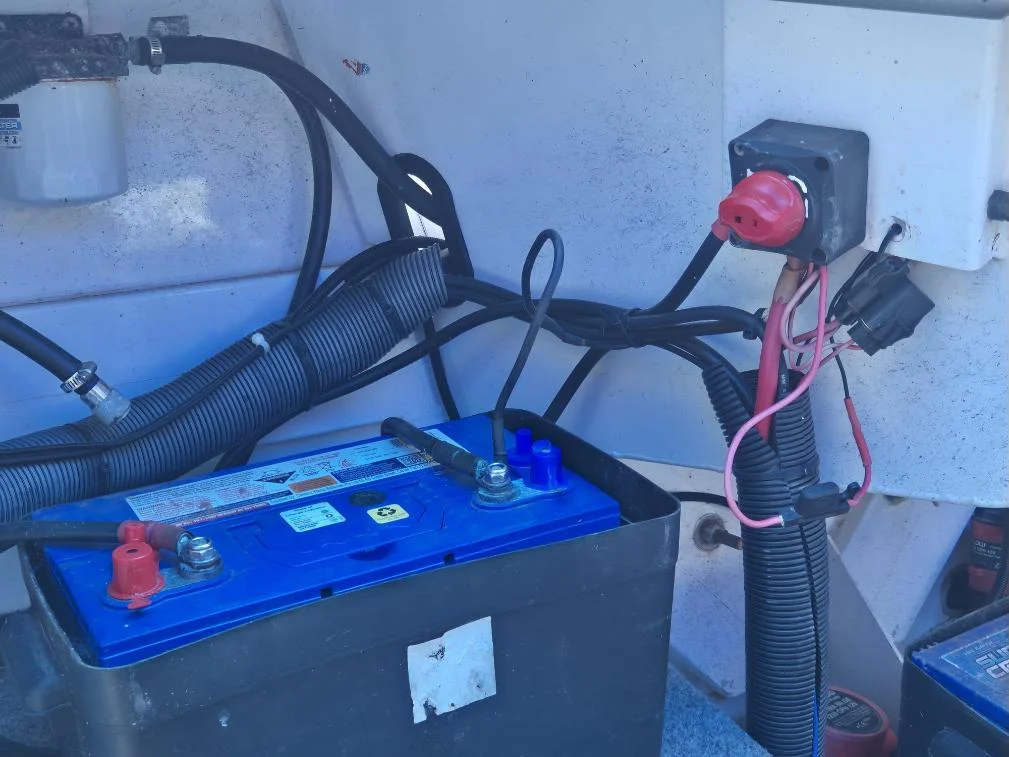 Cranking battery, isolator switch and cable routing in a trailer boat