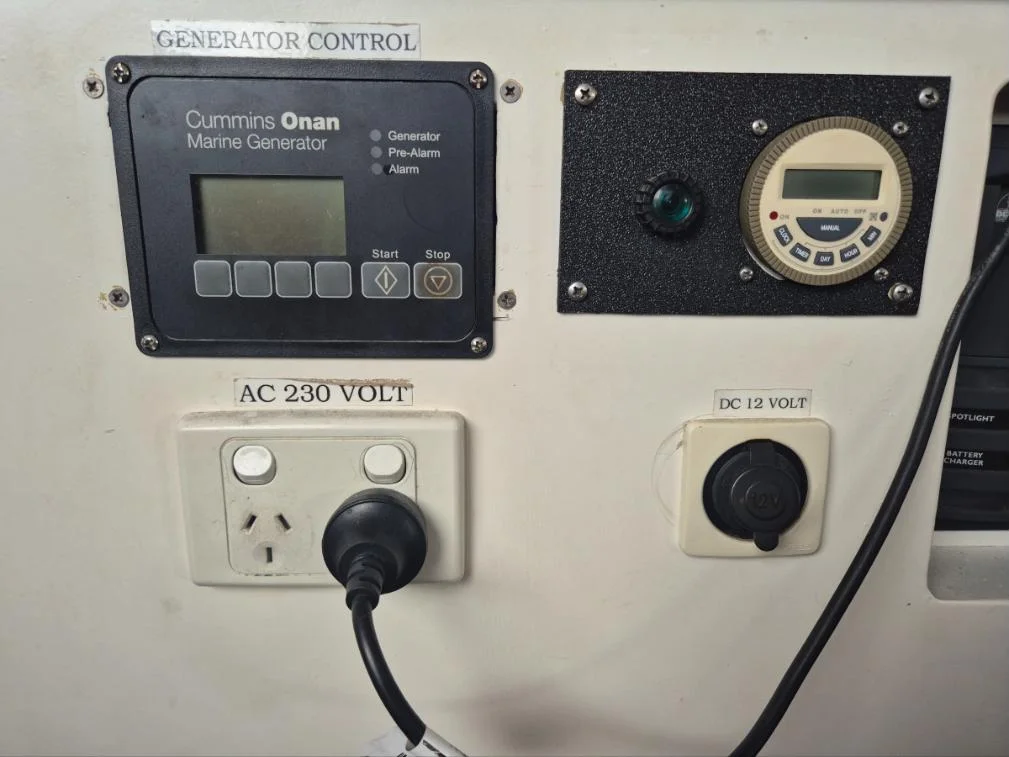 Cummins Onan marine generator control panel with 230V AC and 12V DC outlets