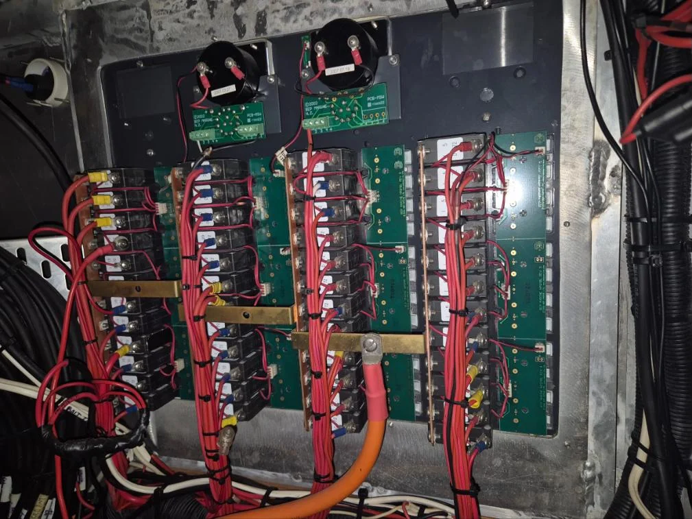 Rear of a marine DC breaker panel with busbars and loomed wiring on a charter vessel