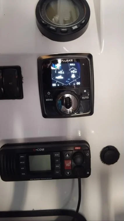 Zipwake trim control panel and GME VHF marine radio installed at the helm
